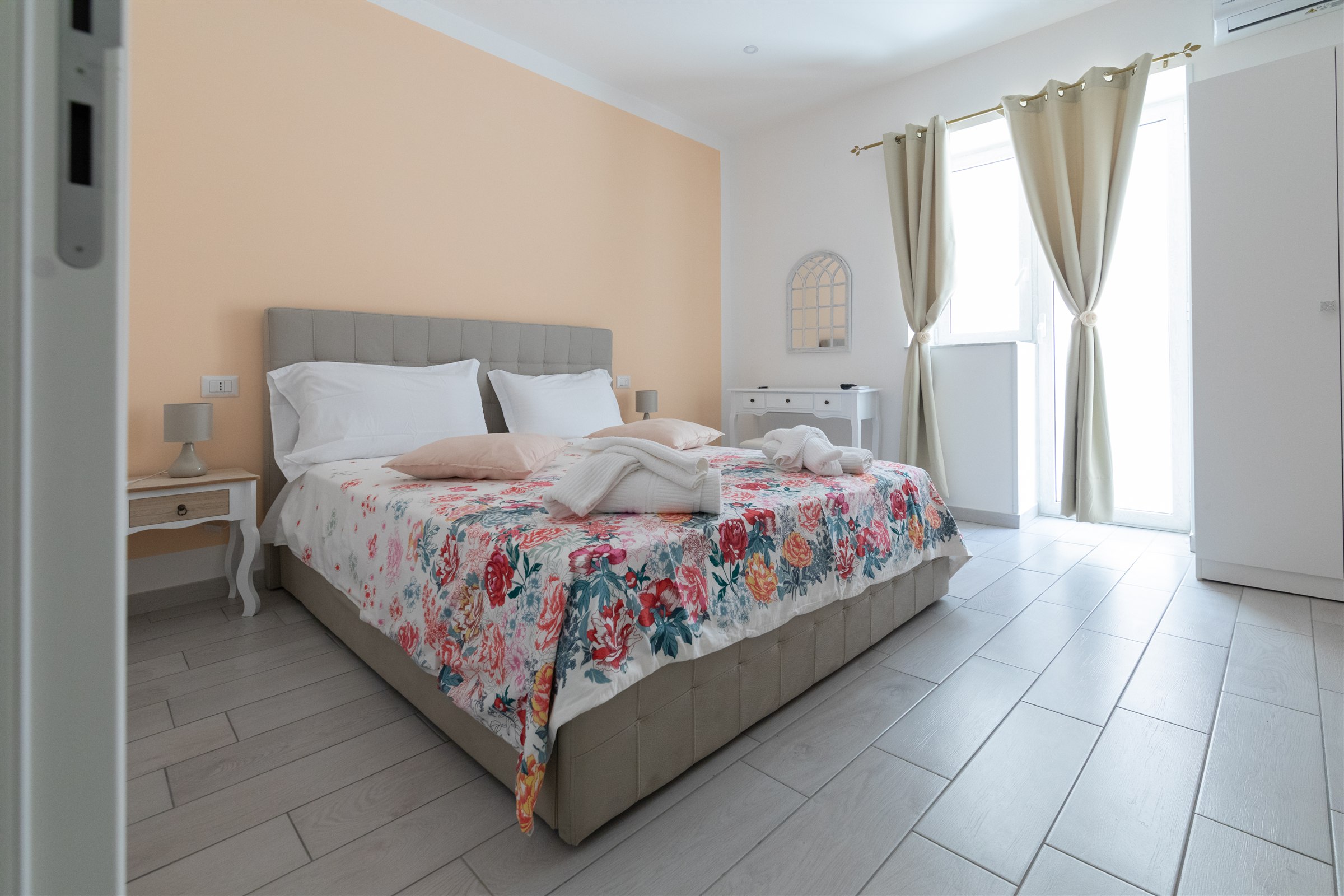 Camera doppia luminosa con letto matrimoniale e tessili floreali