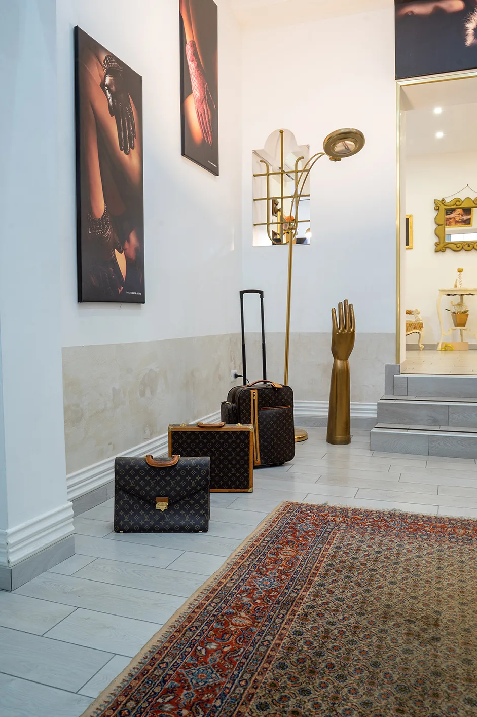 Die Eingangshalle von Gloves Rooms in Neapel mit Vintage-Koffern und Perserteppich