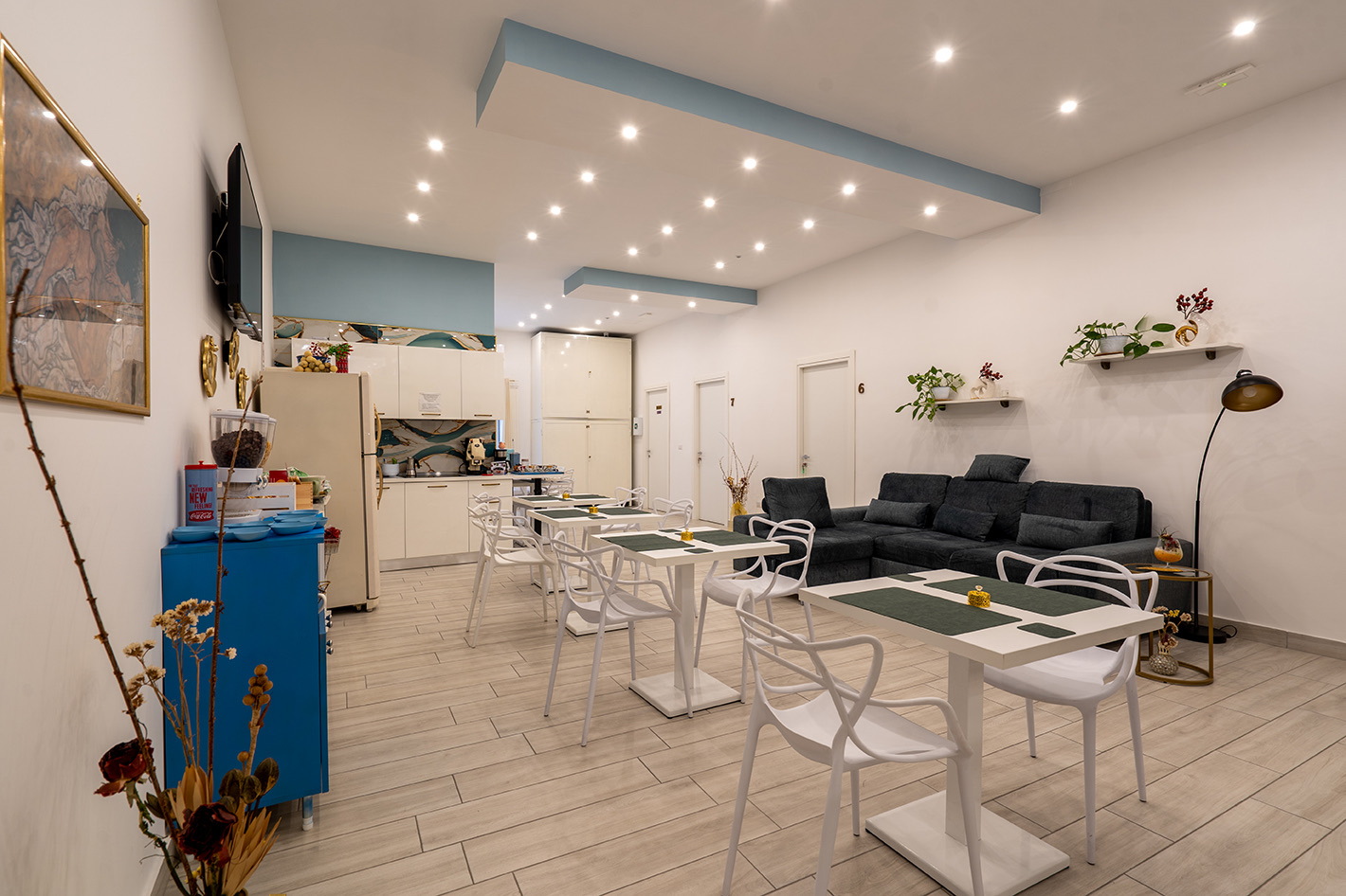 The Gloves Rooms breakfast room with small tables, a kitchen and a sofa