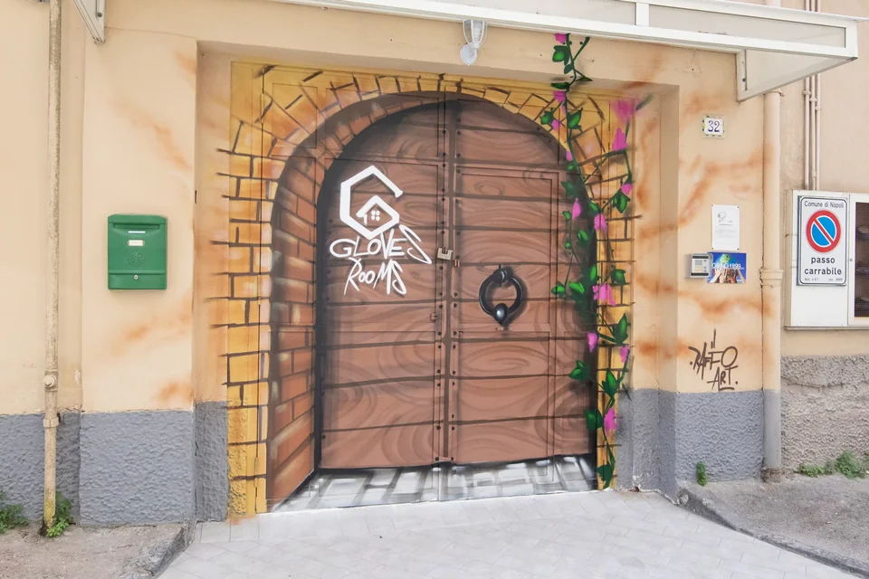 Il portone decorato dell’ingresso di Gloves Rooms a Napoli