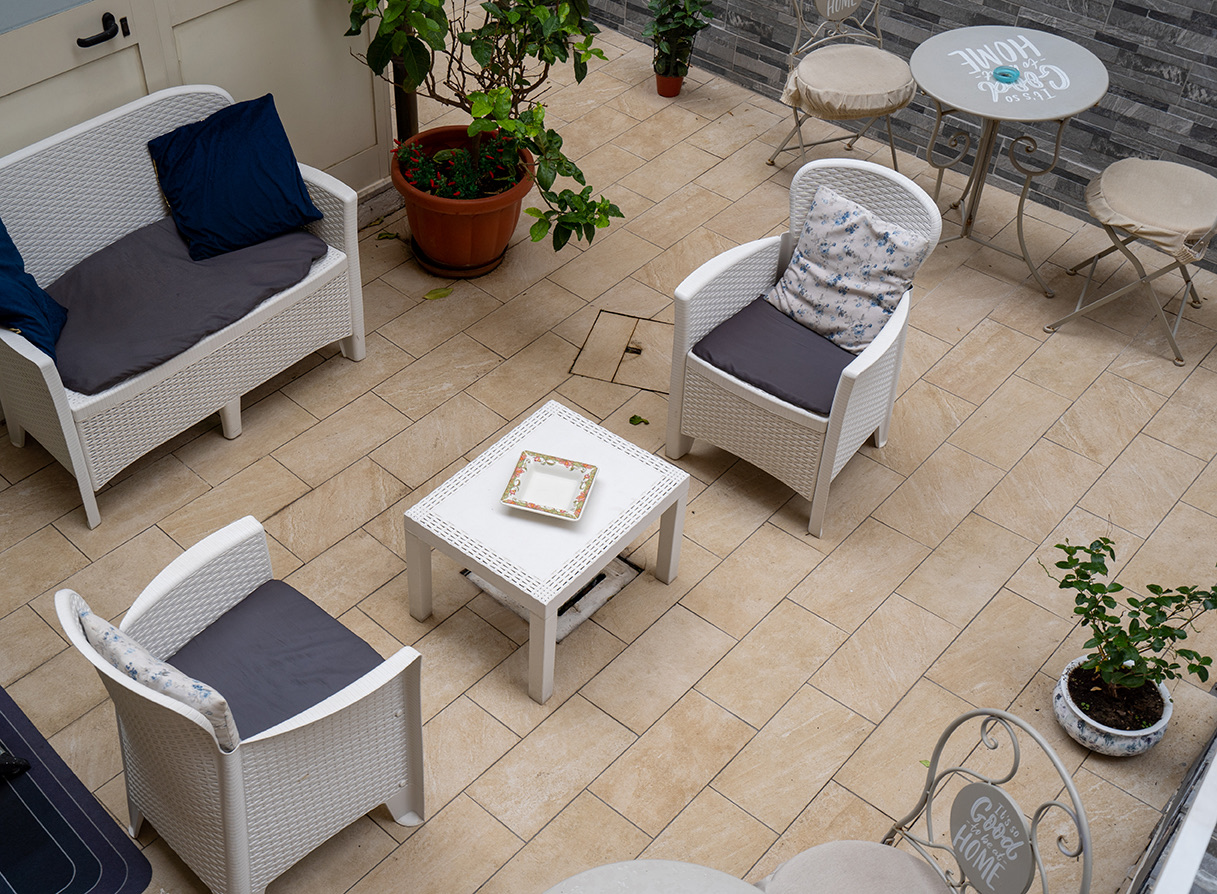 Die Terrasse von oben gesehen, mit kleinem Sofa, Sesseln und kleinen Tischen